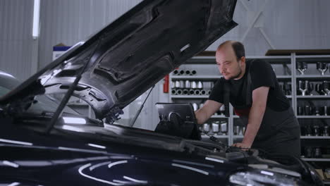 using digital tablet for car diagnostic. mechanic using a tablet pc at the repair garage service. interactive diagnostics software on an advanced computer.