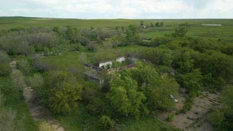 Ruins-of-an-Abandoned-Structure-Surrounded-by-Trees-in-a-Rural-Area-of-Kazakhstan,-Central-Asia---Orbit-Drone-Shot