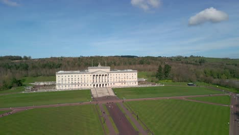 Toma-Amplia-De-Los-Edificios-Del-Parlamento-De-Stormont,-Belfast-Desde-Arriba-En-Un-Día-Soleado-Con-La-Cámara-Subiendo-De-Abajo-A-Arriba