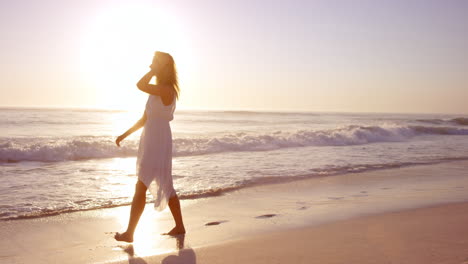 Free-happy-woman-spinning-arms-outstretched-enjoying-nature-playing-on-beach-at-sunset-alone-slow-motion-RED-DRAGON