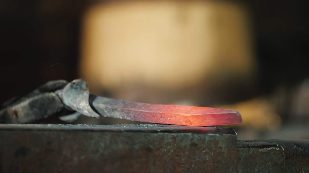 palanquilla de hierro caliente en el yunque un herrero forja un producto de metal - concepto de artesanía tradicional