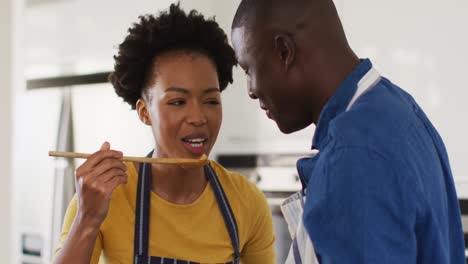 Video-of-happy-african-american-couple-cooking-together,-trying-dish