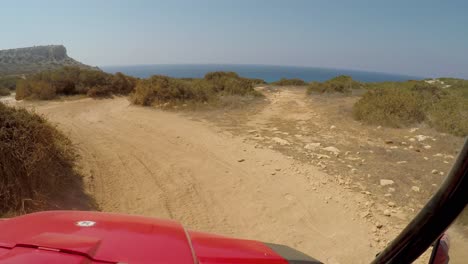 Point-of-view-driving-a-four-runner-ATV-in-Cavo-Greco-towards-the-blue-sea-coast-and-mountains