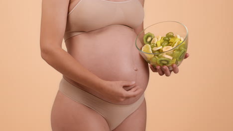pregnant woman holding fruit salad