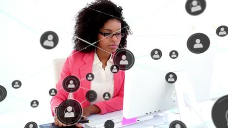 animation of connected icons over african american woman writing in notepad and typing on laptop