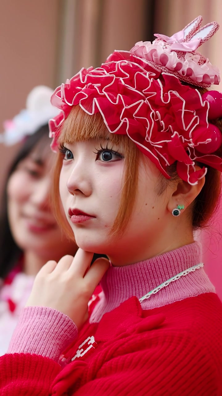 Cận cảnh một phụ nữ Nhật Bản mặc trang phục phong cách Lolita diềm xếp nếp màu đỏ ở Harajuku, Tokyo.