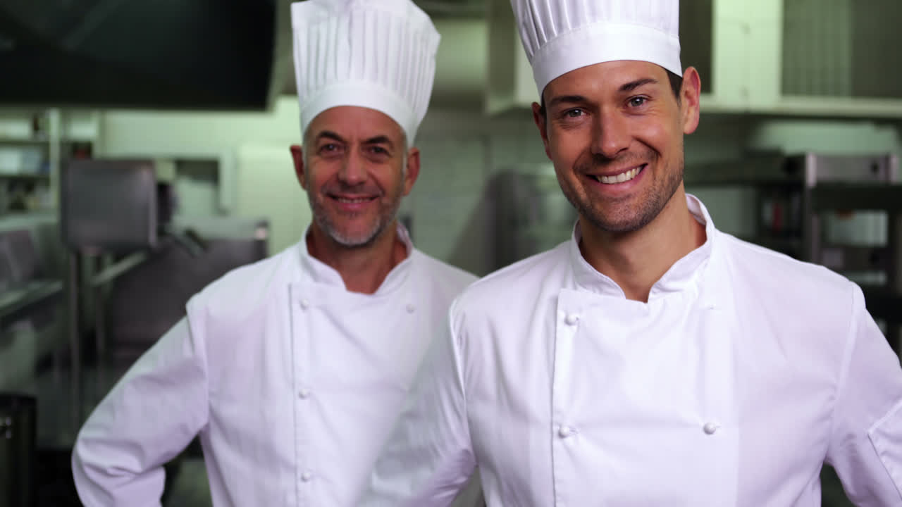 dos cocineros sonrientes dando pulgares hacia la cámara