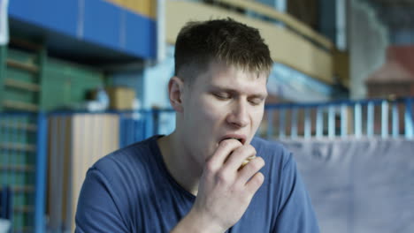 man eating a snack in a gym