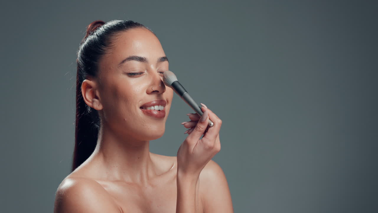 A beautiful woman applying makeup with a brush