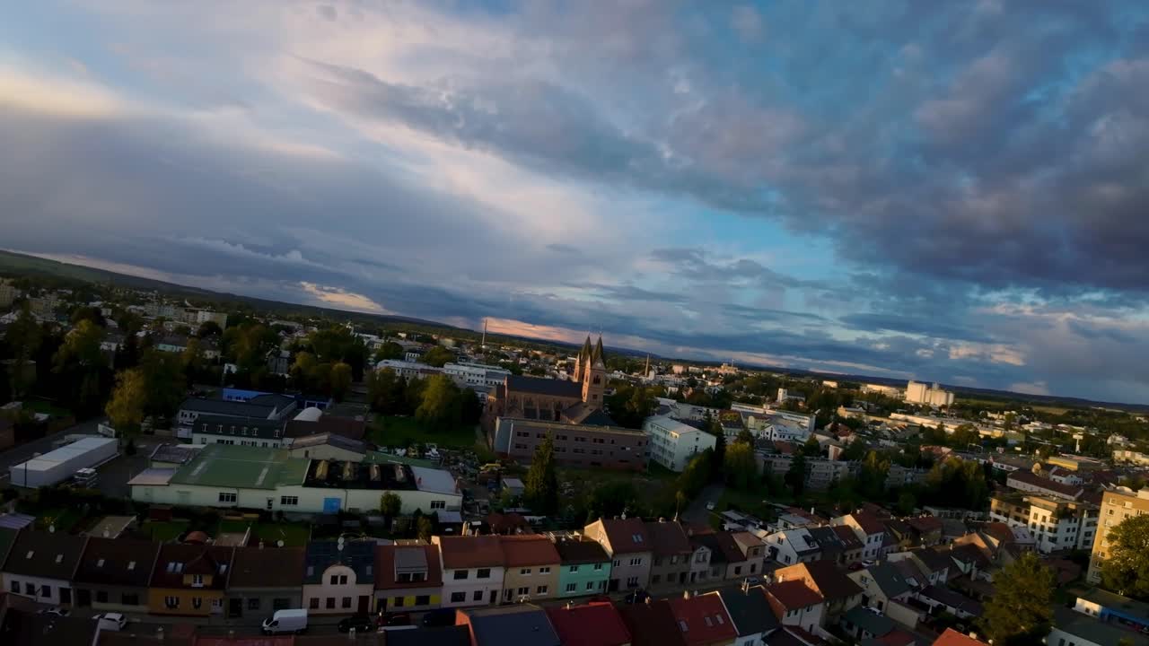 Byen Svitavy i Tjekkiet med familiehuse og ejendomme i et byområde med en rød kirke i solrigt efterår
