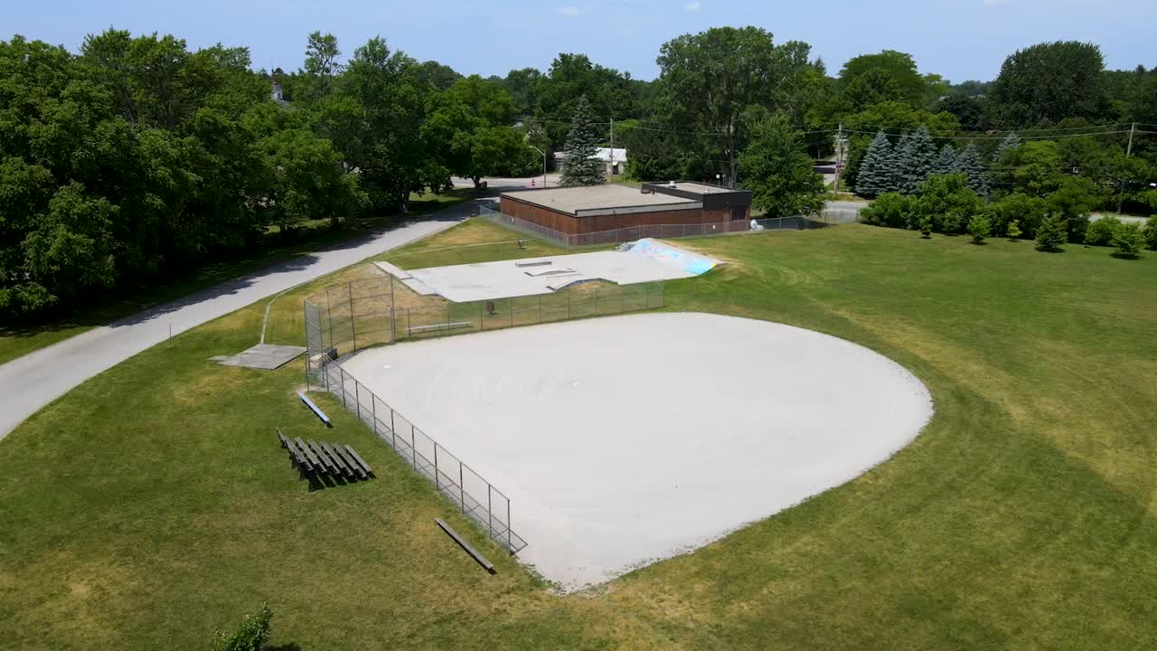 Volo intorno a un campo da baseball e uno skate park in una giornata di sole in una piccola città vicino a London, Ontario.