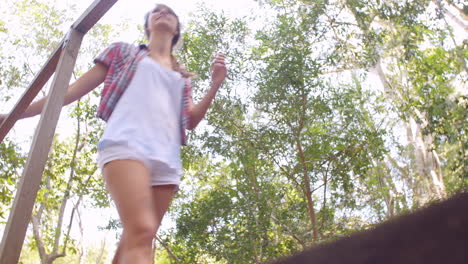 friends crossing a small bridge in a forest, low angle