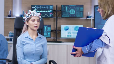 médico de neurología sosteniendo el clipboard frente a la paciente femenina