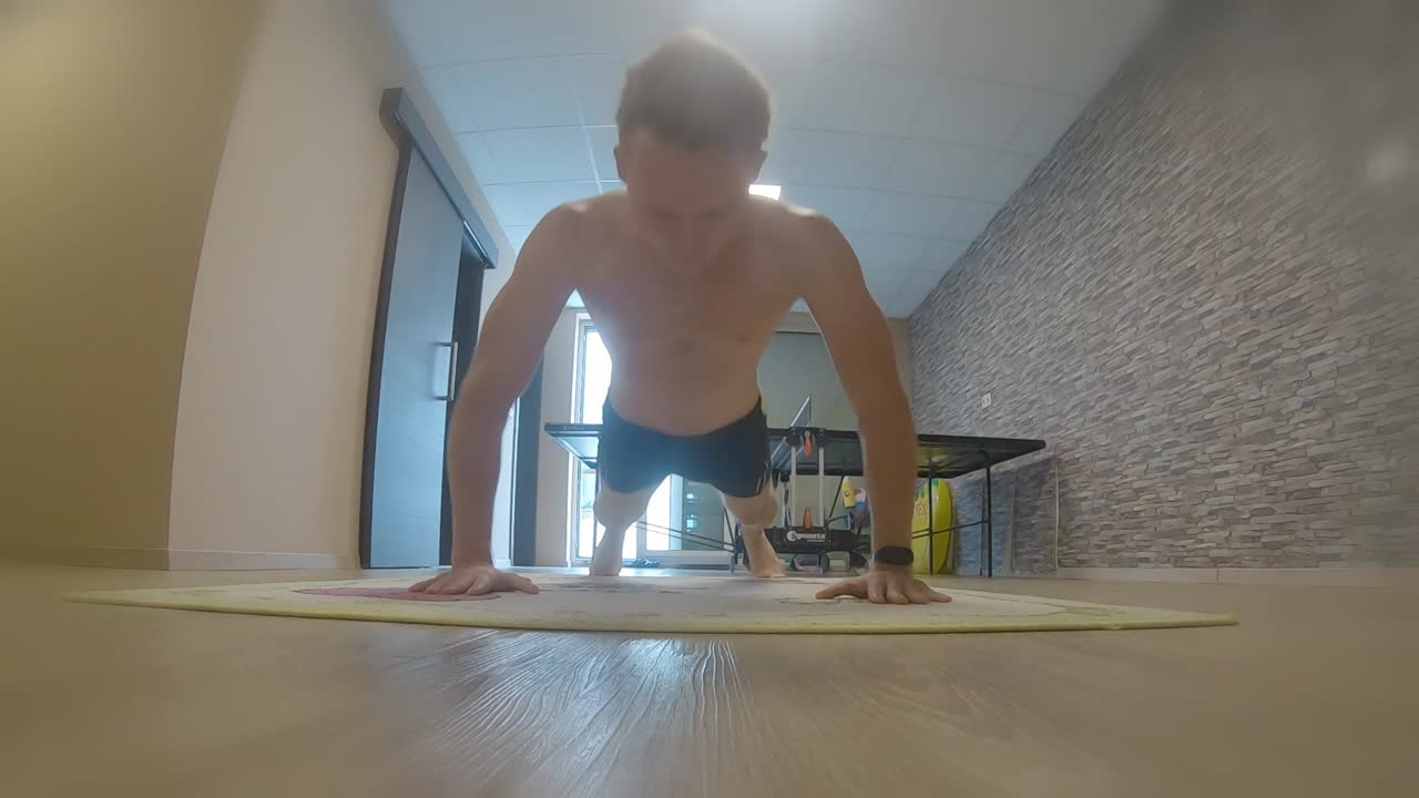 Teenager doing push ups in home gym fitness arms workout action shot