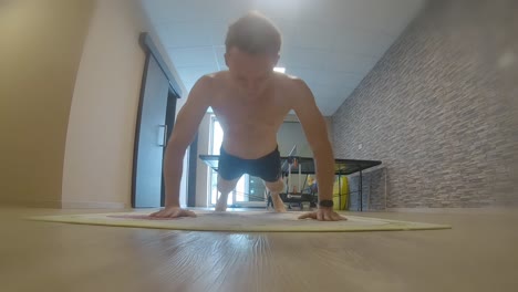 teenager doing push ups in home gym fitness arms workout action shot