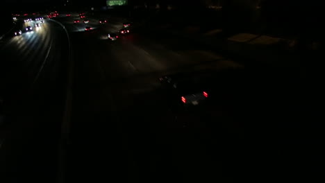 stationary tilt shot of cars on the freeway at night