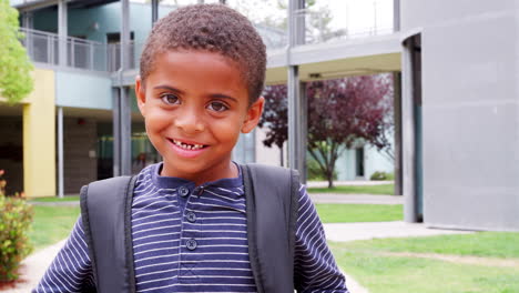 mixed race elementary schoolboy smiling to camera, outdoors