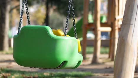 empty green plastic swing in a park