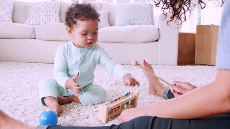 Schwarzes-Kleinkind-Spielt-Xylophon-Mit-Seiner-Mutter-Im-Wohnzimmer