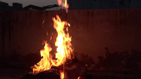 a closeup shot of fire burning outside at night on terrace roof