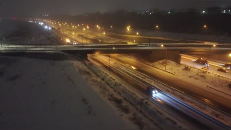 night highway traffic with snowy conditions in montréal, québec, canada