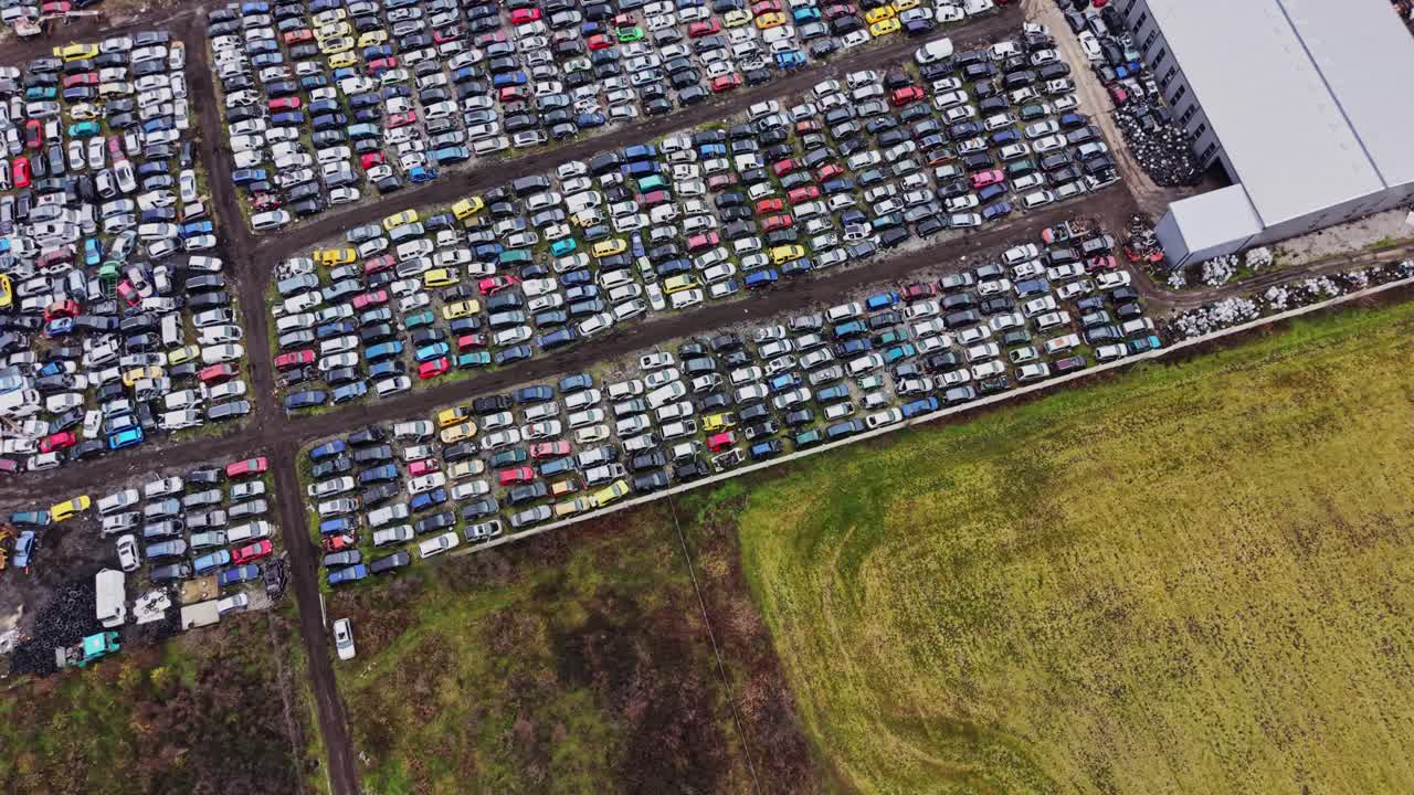 Aparcamiento concurrido con muchos coches durante el día en una zona rural