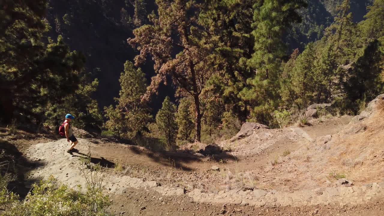 화산섬에서 길을 내려가는 여성을 따라가는 샷
