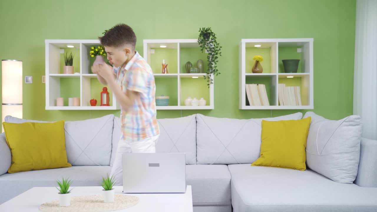 Funny and cheerful little boy. He does taekwondo at home. The boy wants to be strong.