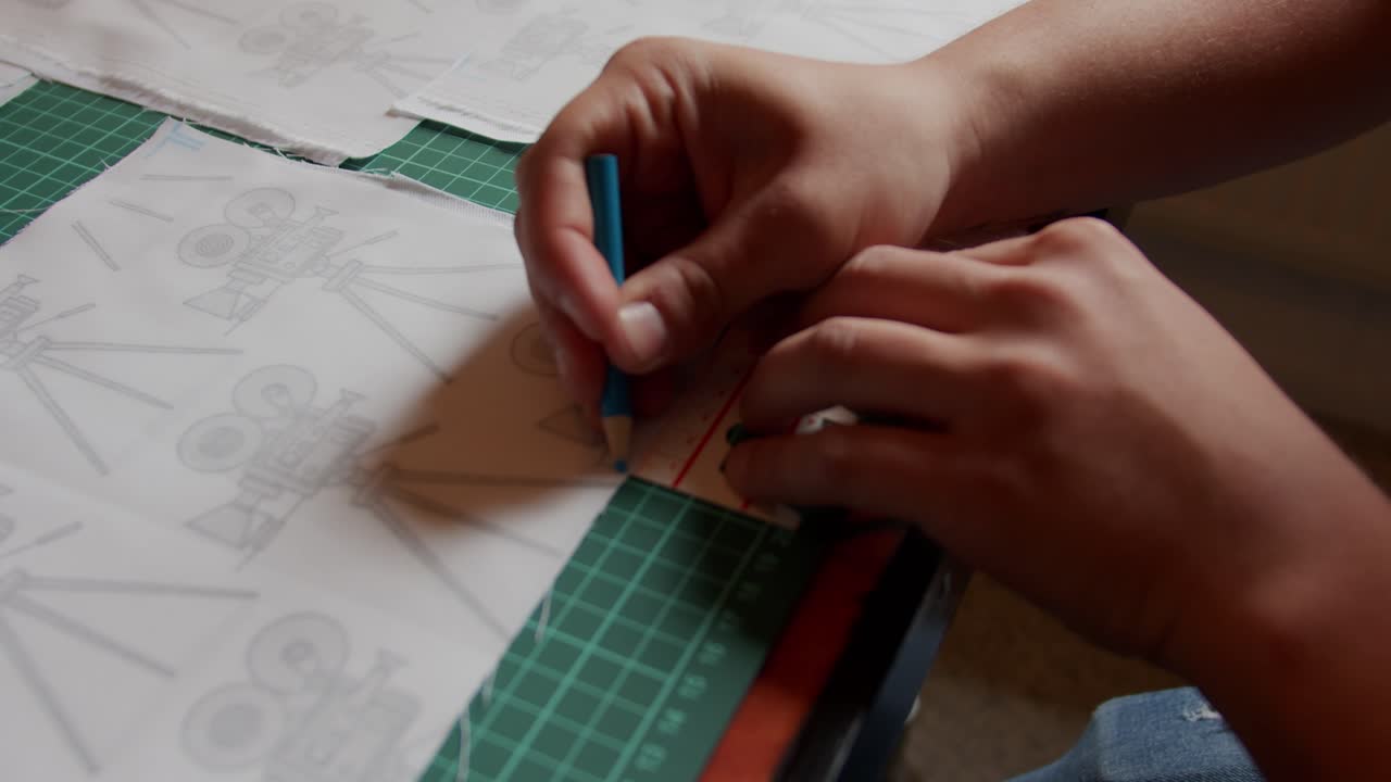 Marking onto fabric on a cutting board using a blue marker. Slow motion.