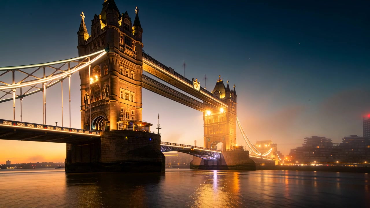 Tower Bridge brilhante emitindo um brilho quente no Rio Tâmisa enquanto o pôr do sol se desvanece, com holofotes iluminando.