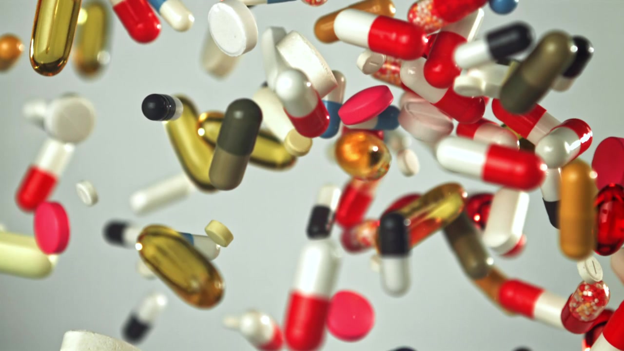 Assortment of Colorful Pills and Capsules Falling in Slow Motion
