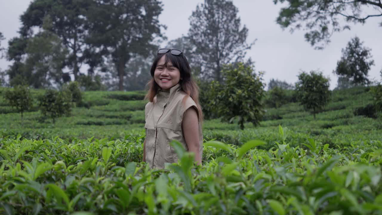 Cheerful happy expression, young Asian female, lush green vegetation