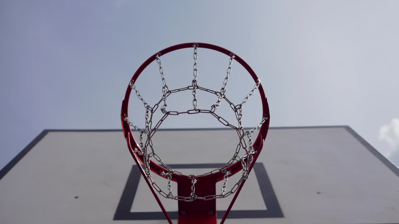 cubo de baloncesto. canasta con red de cadena metálica en un soleado día de verano cerca en el fondo de un cielo azul claro. concepto de campo de juego urbano moderno