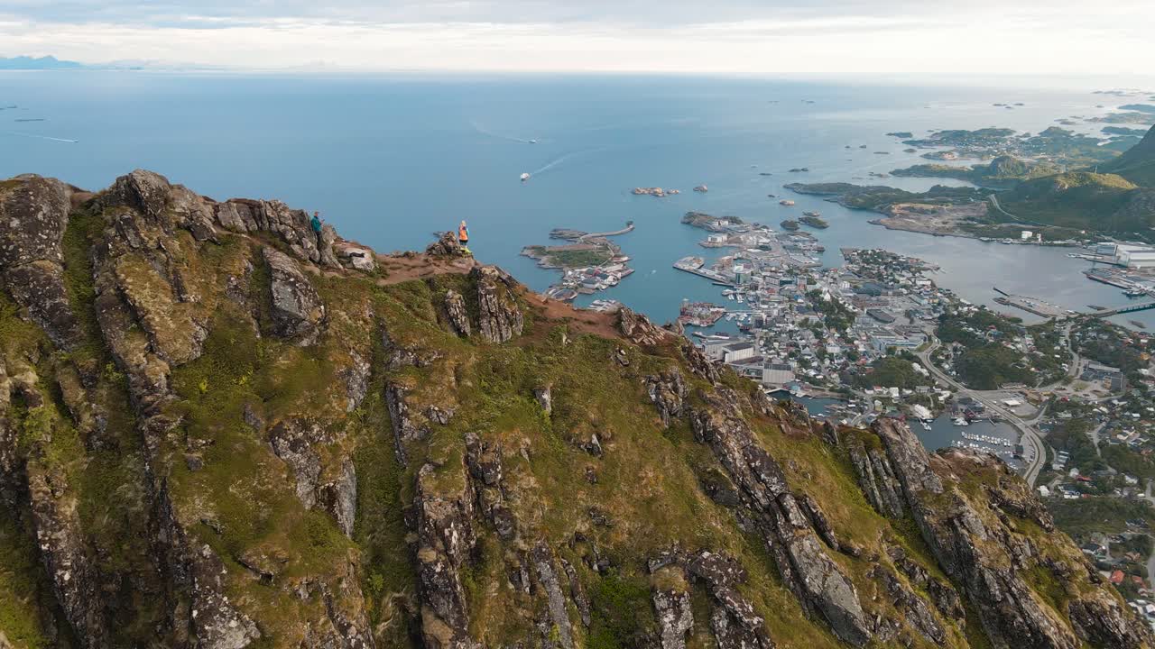 Revealing aerial shot of Svolv&aelig;r in Lofoten, Norway from mountain top, Fl&oslash;ya and Djevelporten drone footage