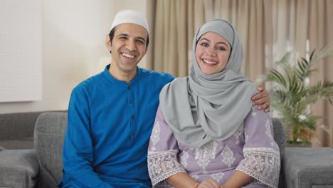 happy muslim couple laughing on someone