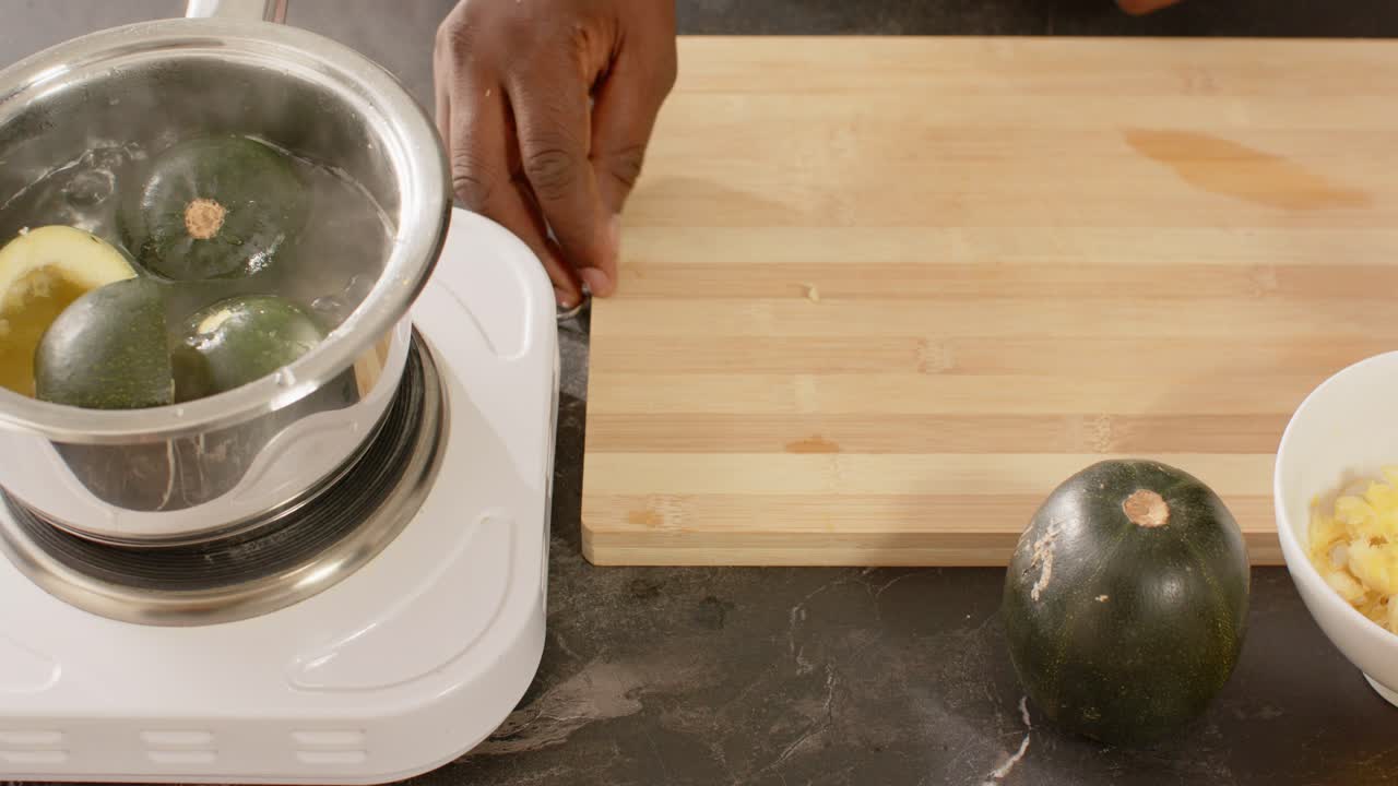 Vertical video: African American man scooping pulp, putting shells into pot for steaming
