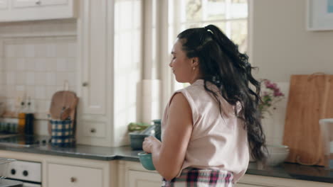 happy overweight teenage girl dancing in kitchen having fun celebrating weekend performing funny dance moves at home enjoying weekend celebration