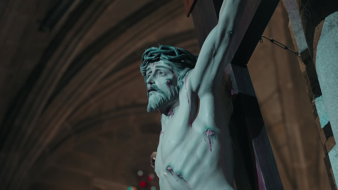 wounded jesus gazes upward from the crucifix in solemn church silence