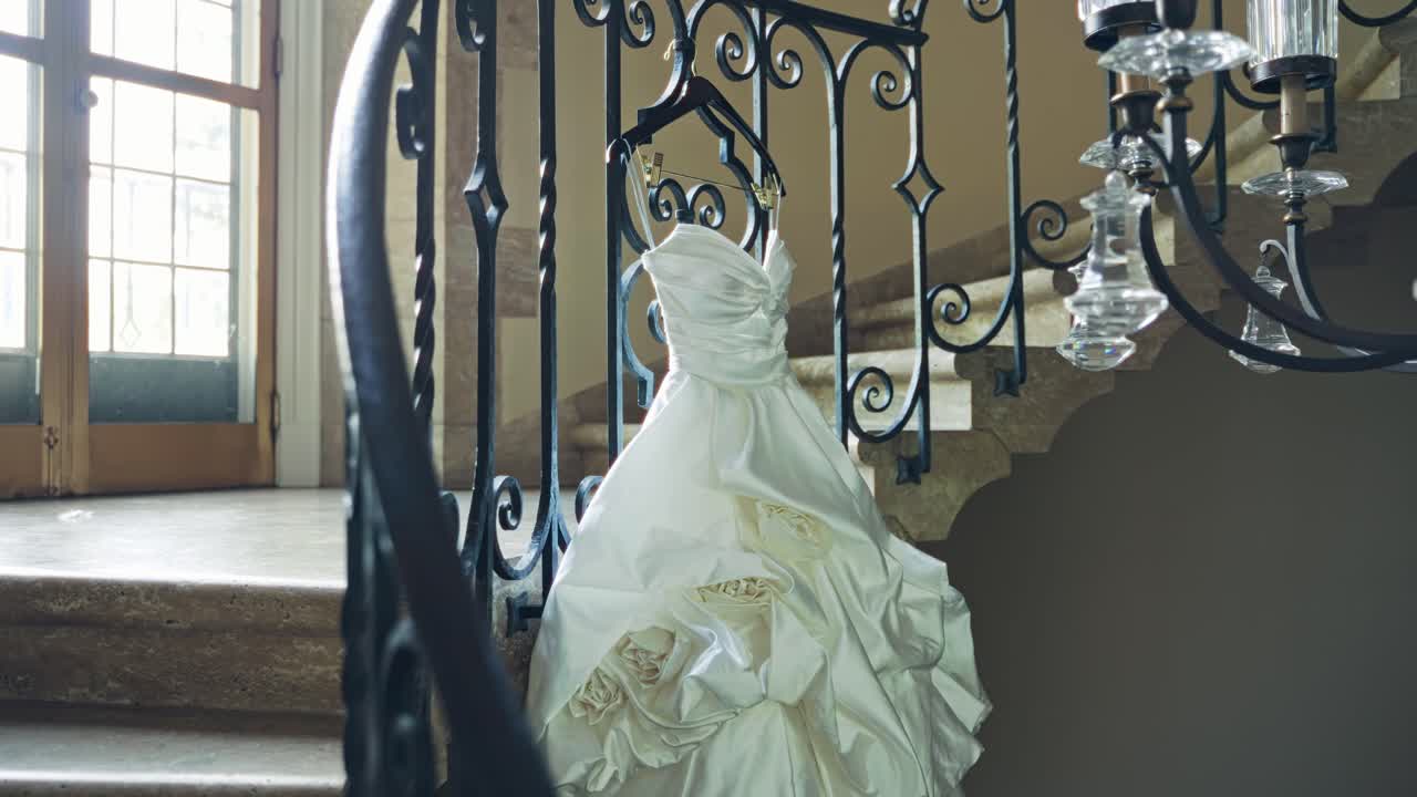 우아하고 멋진 웨딩 드레스가 우아하게 장식된 나선형 계단에 표시되어 있습니다.