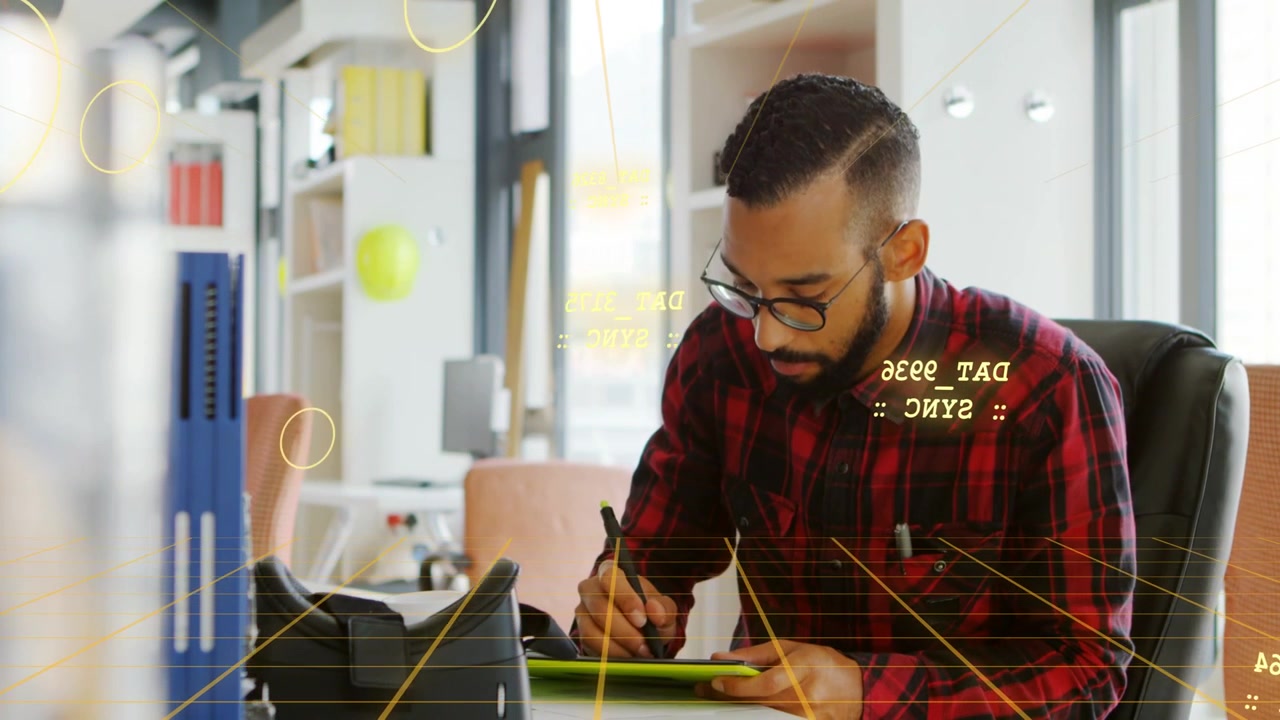 Male designer tapping desk item resuming drawing on green tablet for review with yellow HUD syncing