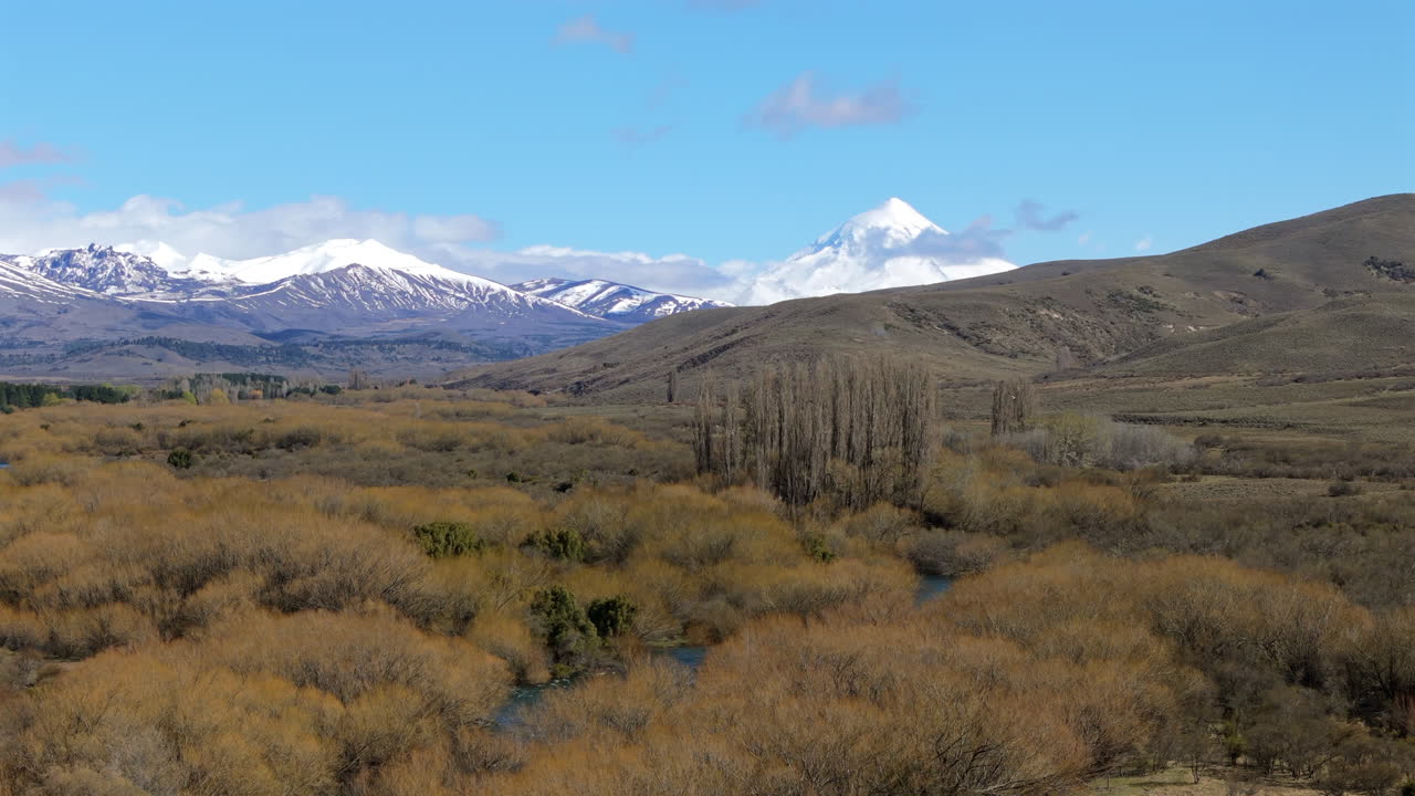Breathtaking View of a Snow-Capped Volcano and River Valley