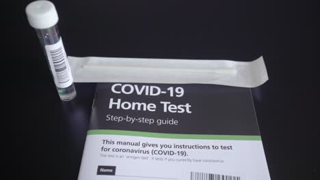 right to left pan of covid-19 coronavirus home test kit with guide, test tube and cotton q tip