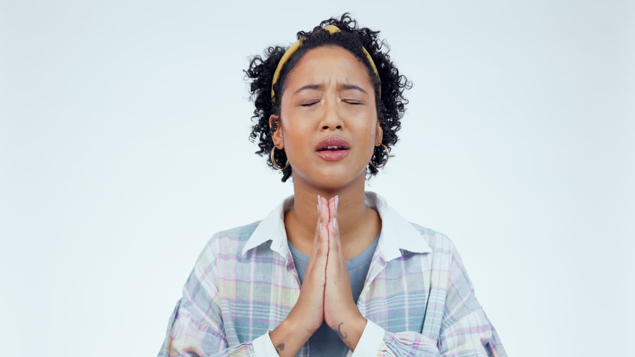 Hands, hope and nervous woman praying in studio
