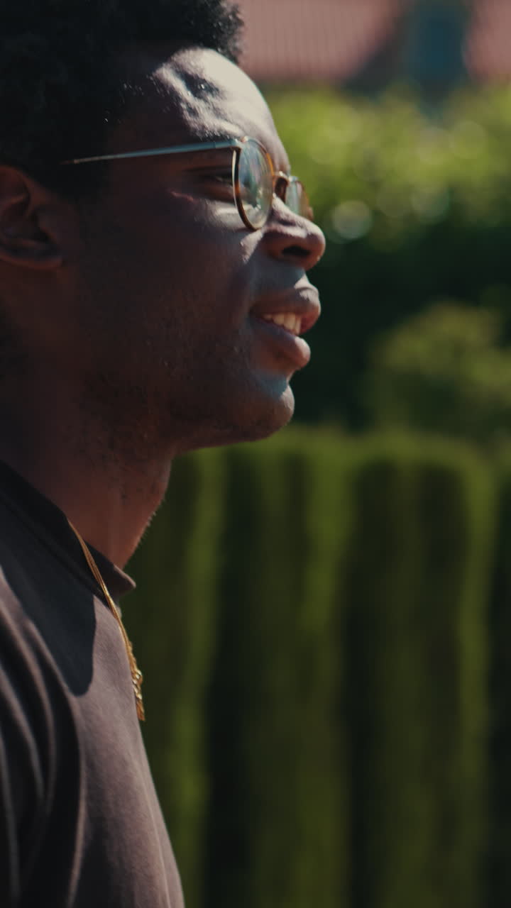 Profile of Young Black Man Talking Outdoors in Sunlight