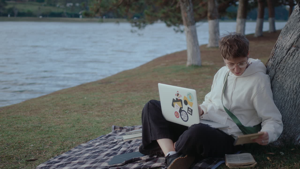 Girl Studying Online with Laptop and Taking Notes in the Park