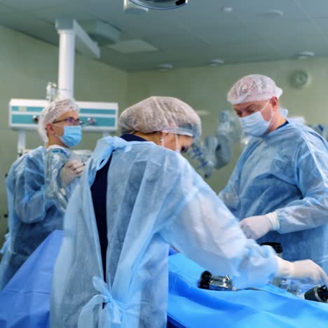 team of doctors in the operating room. group of medical workers in blue uniform conduct an operation with surgical equipment in the hospital.