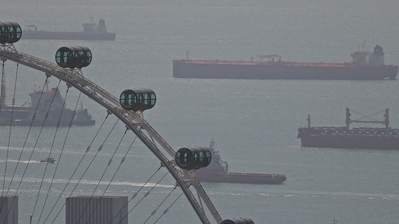 container ships and ferris wheel in singapore