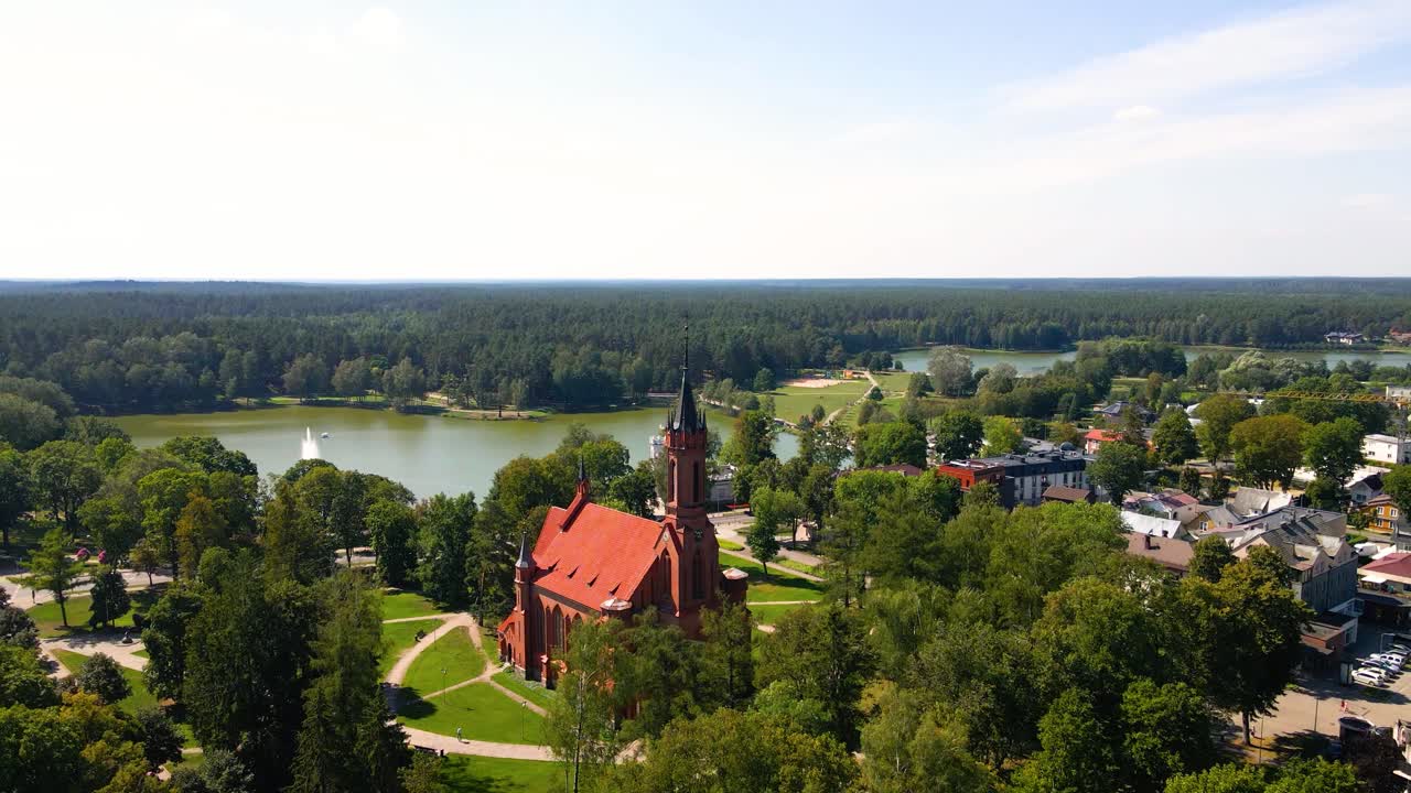 Aerial shot of the Catholic Church of Saint Mary's Scapular in Druskininkai, Lithuania on a sunny summer day, zoom in