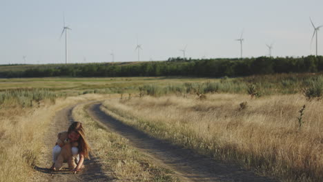child playing with teddy bear in a countryside field