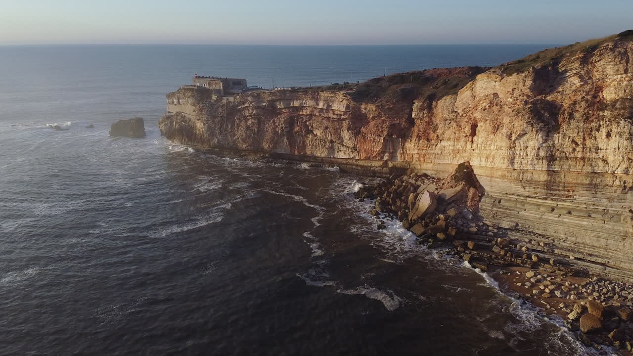 vista aérea del faro de nazare y las rocas en portugal al atardecer
